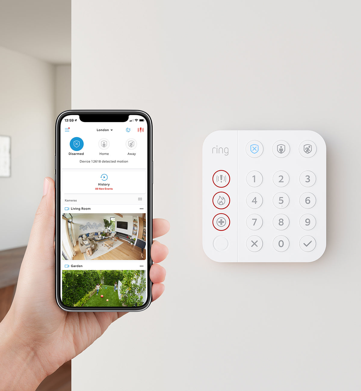 A hand holds a phone displaying a security app. A white keypad with numbers and symbols is on the wall beside it.