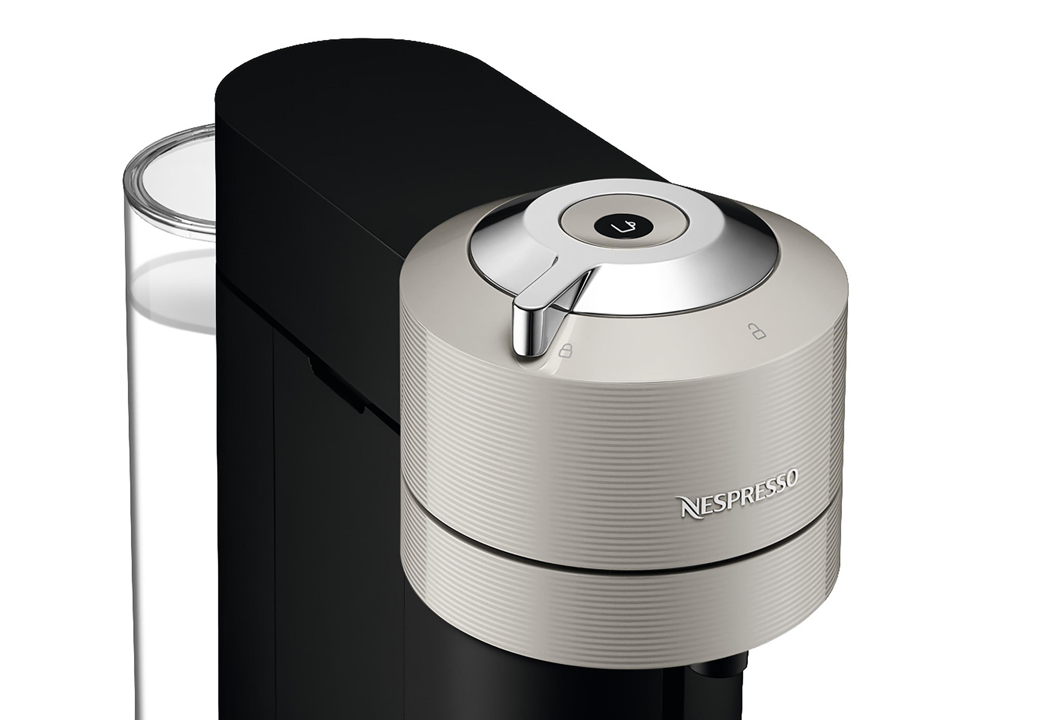 Nespresso-Kaffeemaschine, Nahaufnahme der Oberseite mit silbernem Knopf.
