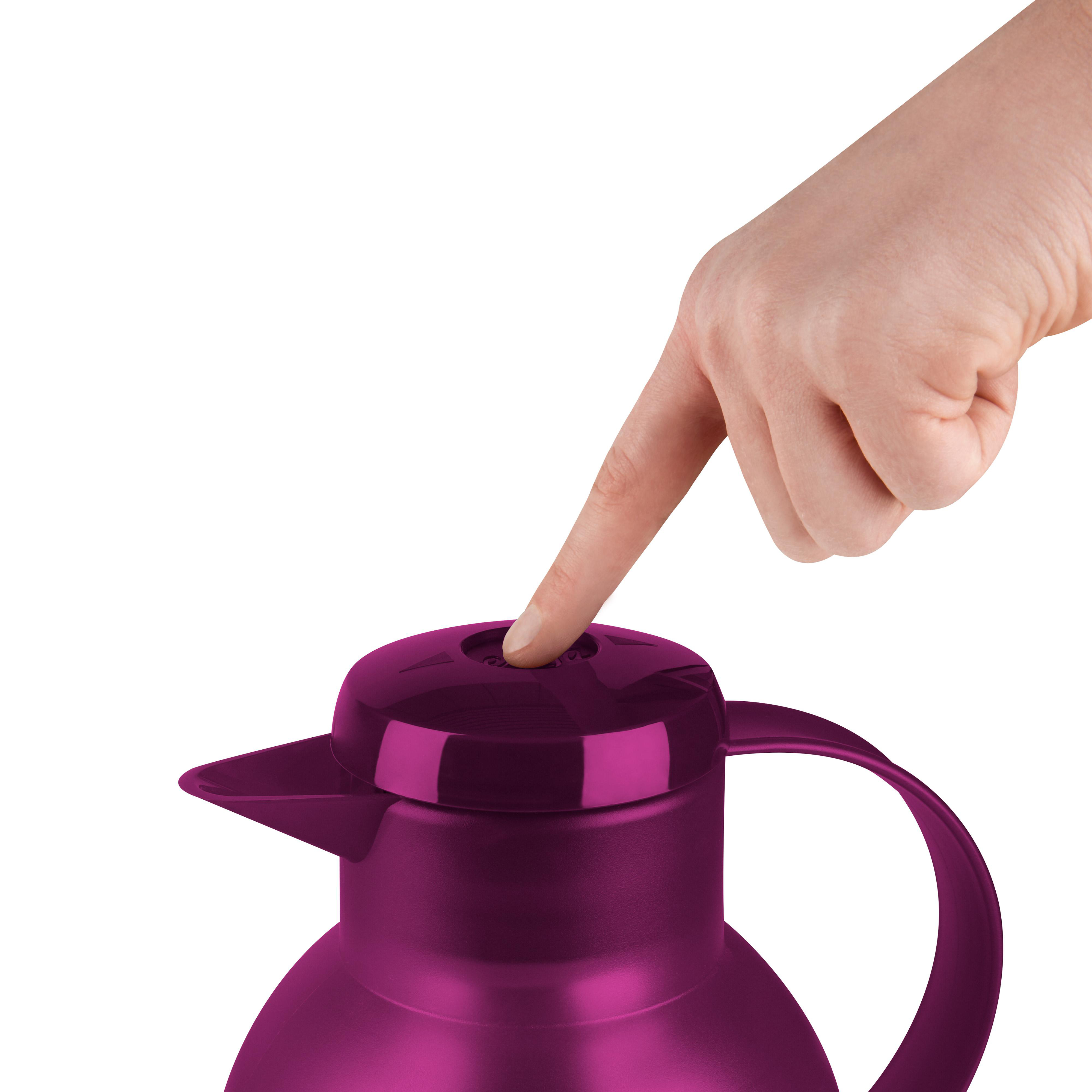 Eine Hand drückt die obere Taste einer lila Thermoskanne, isoliert vor weißem Hintergrund.