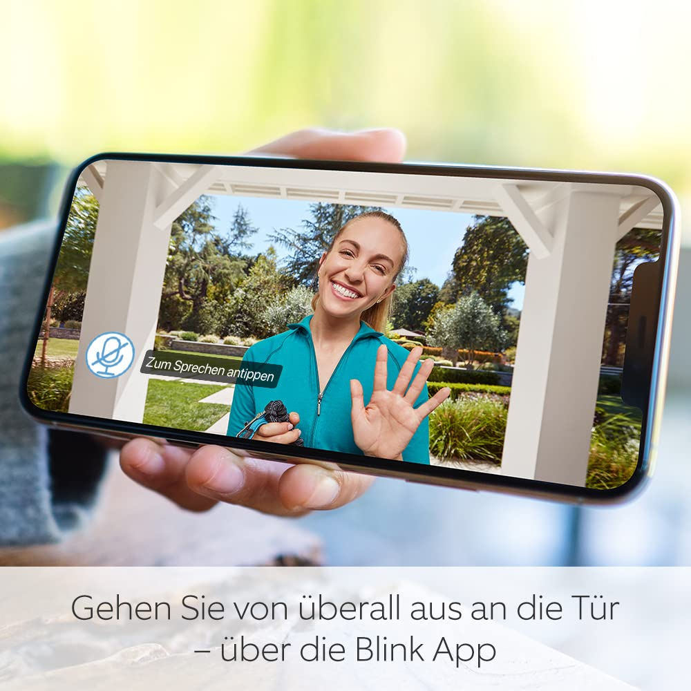 Eine Frau lächelt auf dem Telefonbildschirm. Das Telefon wird von einer Hand gehalten.