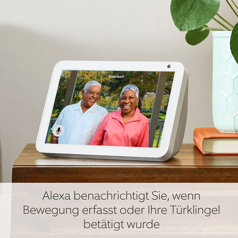 Smart Display zeigt zwei lächelnde Personen. Text: Alexa benachrichtigt bei Bewegung.