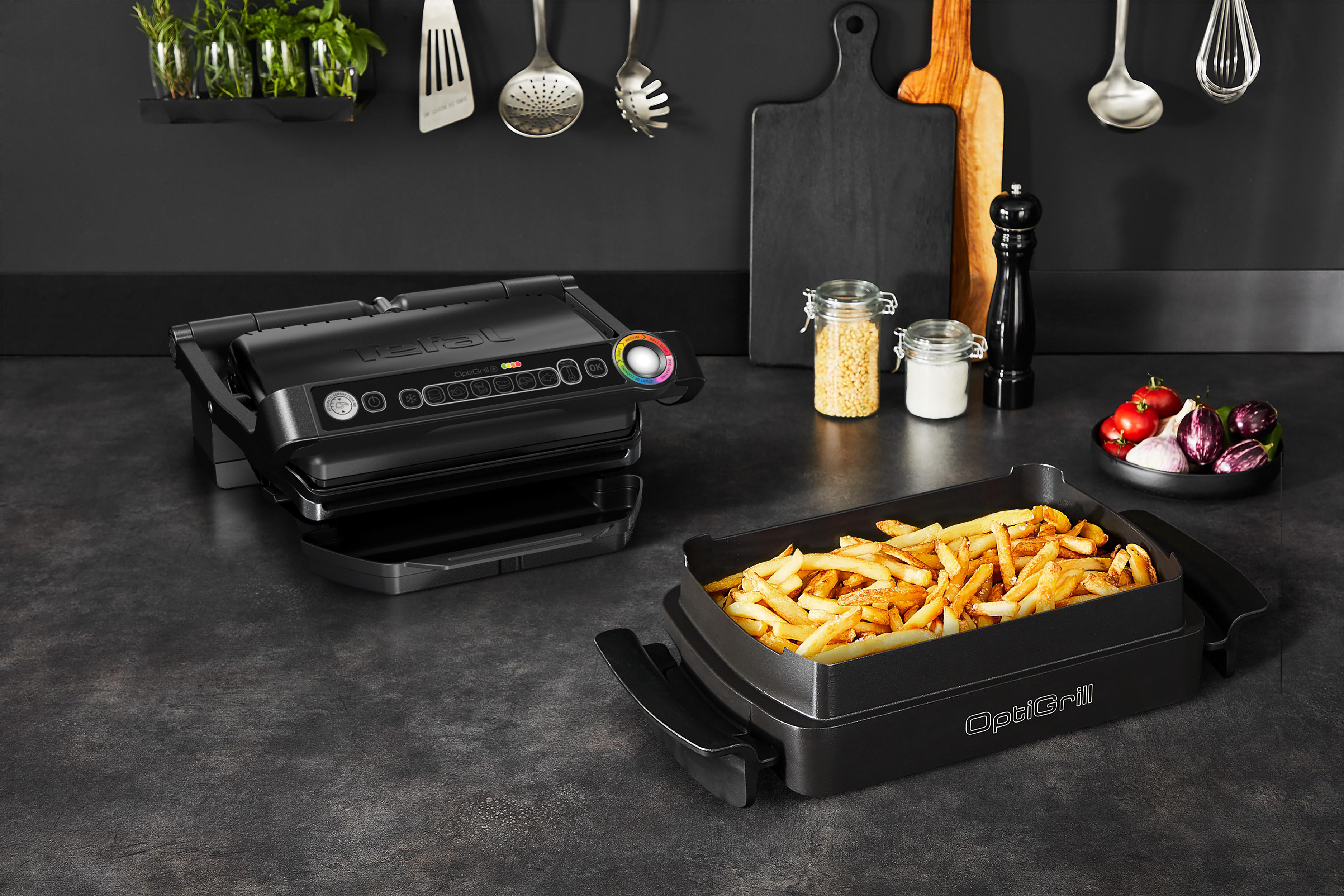 Ein schwarzer OptiGrill mit einem Tablett Pommes und etwas Gemüse auf einer Theke.