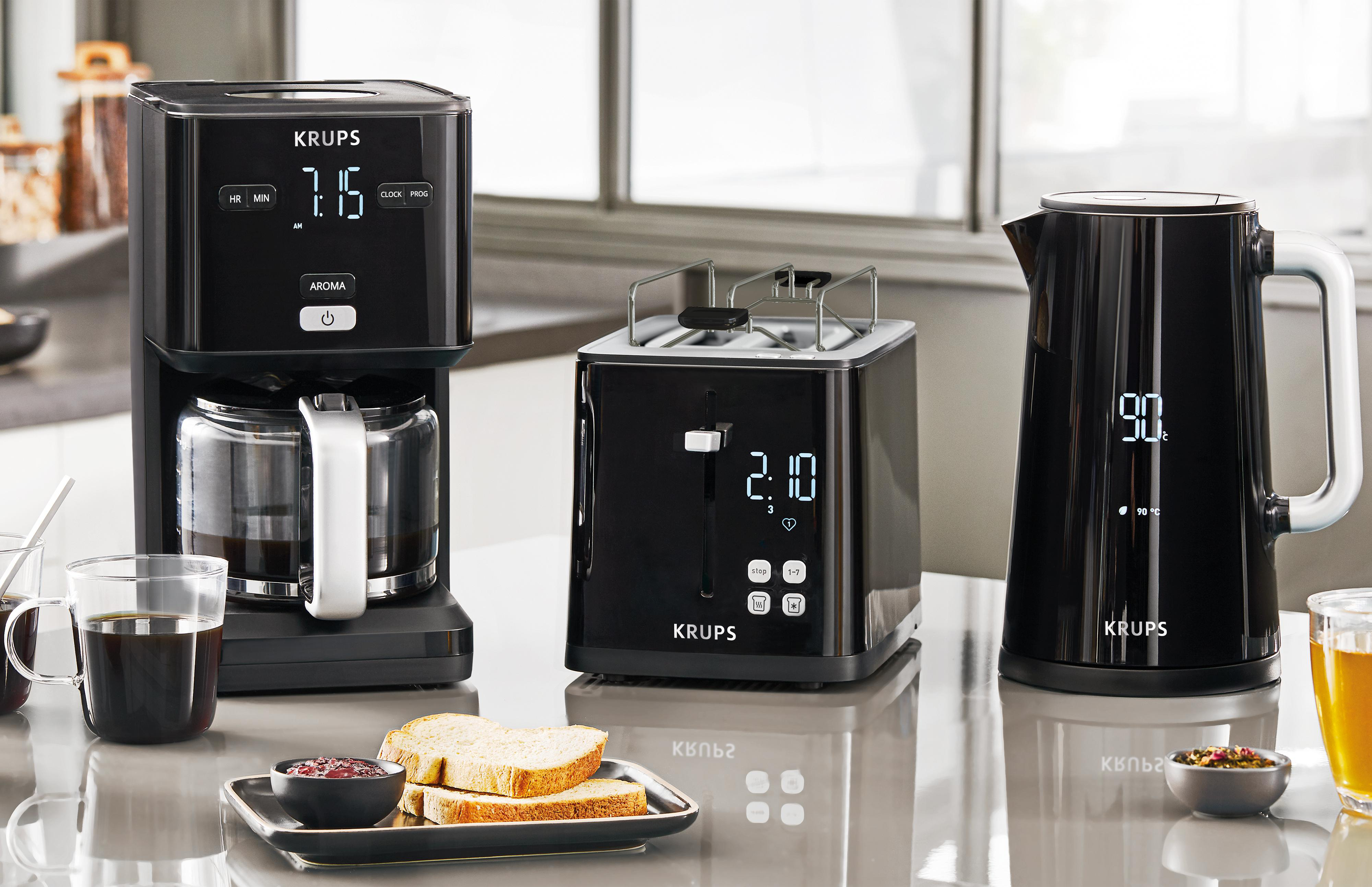 Kaffeemaschine, Toaster und Wasserkocher auf einer Theke mit Toast und Marmelade.