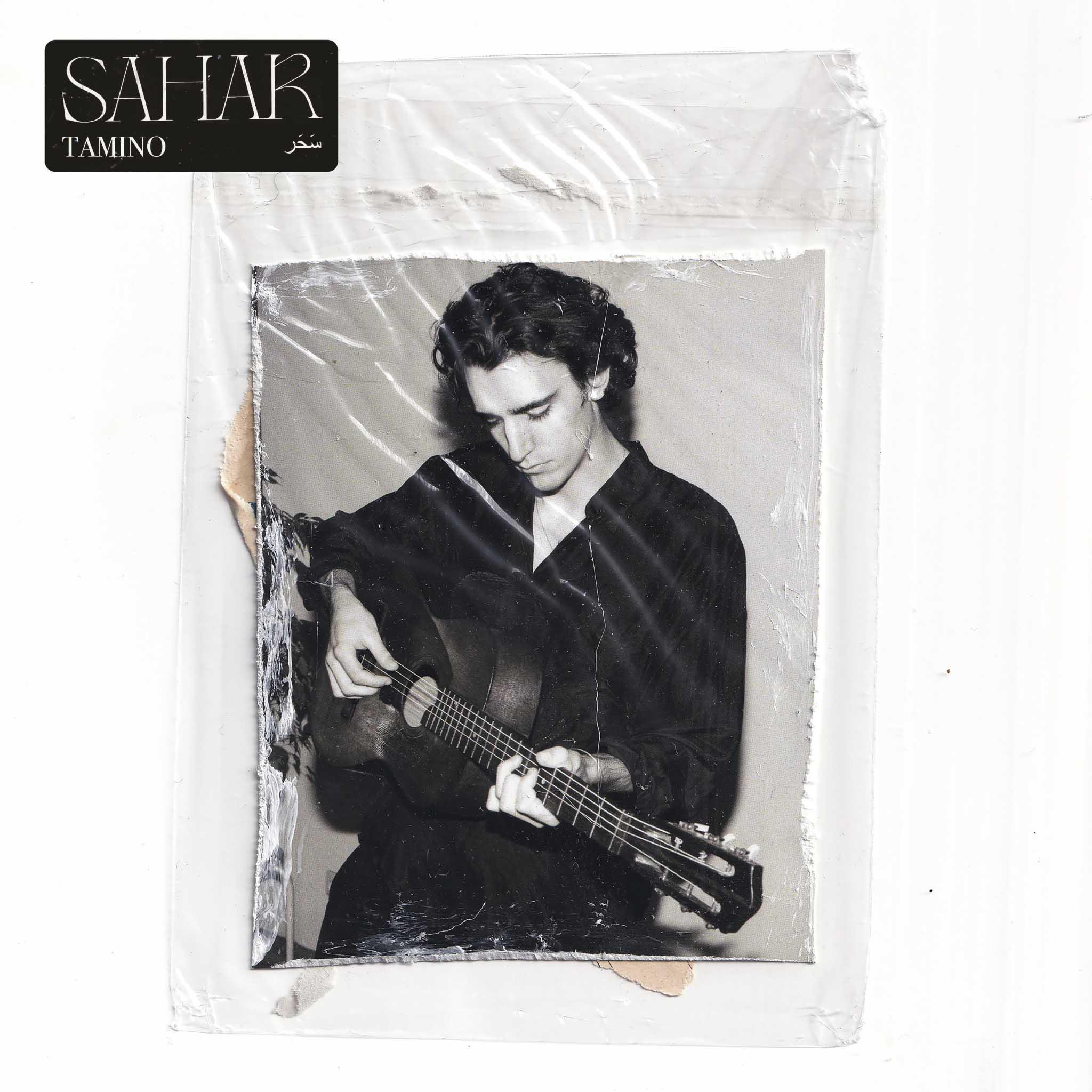Schwarz-Weiß-Foto eines Mannes, der Gitarre spielt, in einer Plastikhülle.