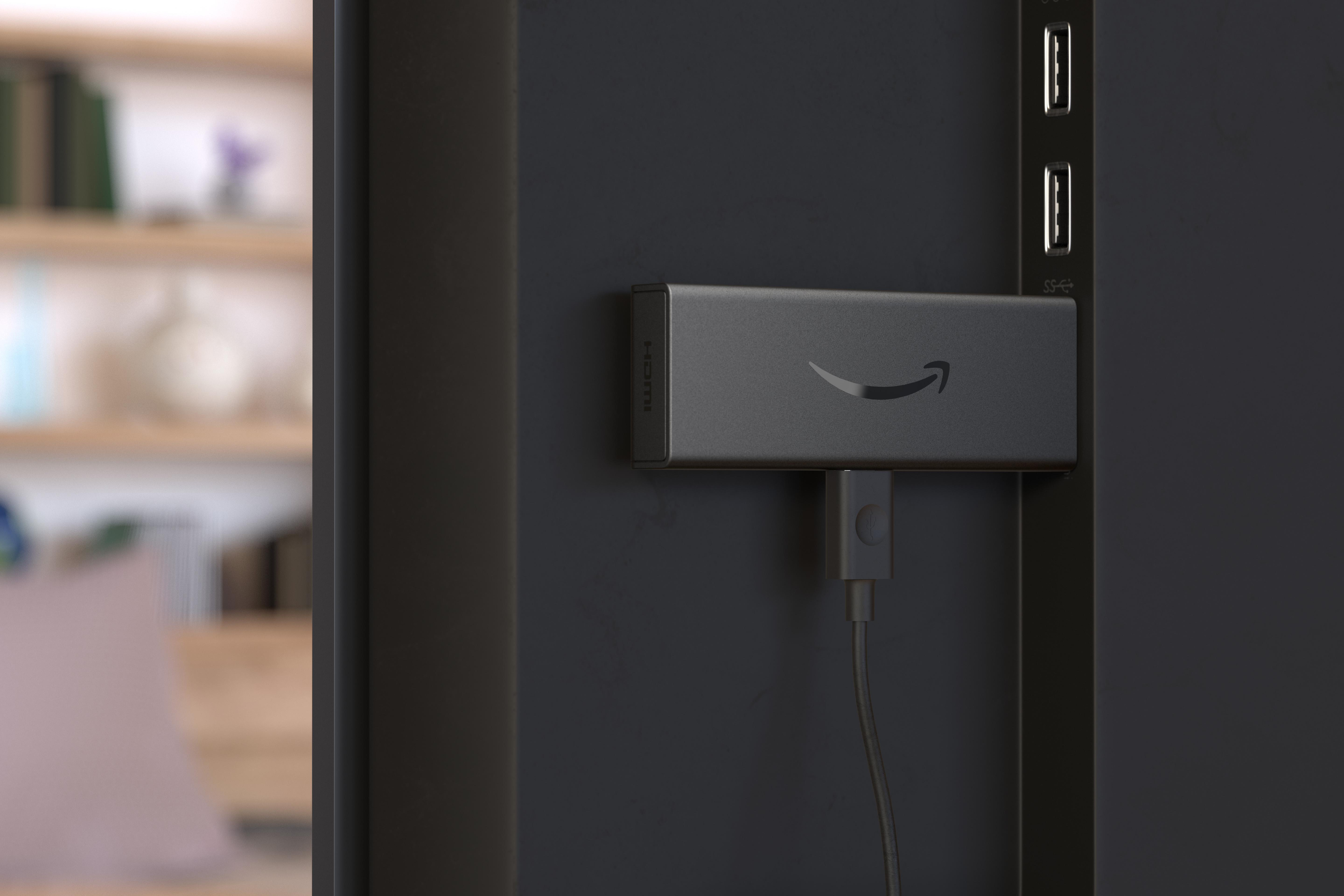 Amazon Fire TV Stick, der an einen Fernseher angeschlossen ist, mit schwarzem Hintergrund.