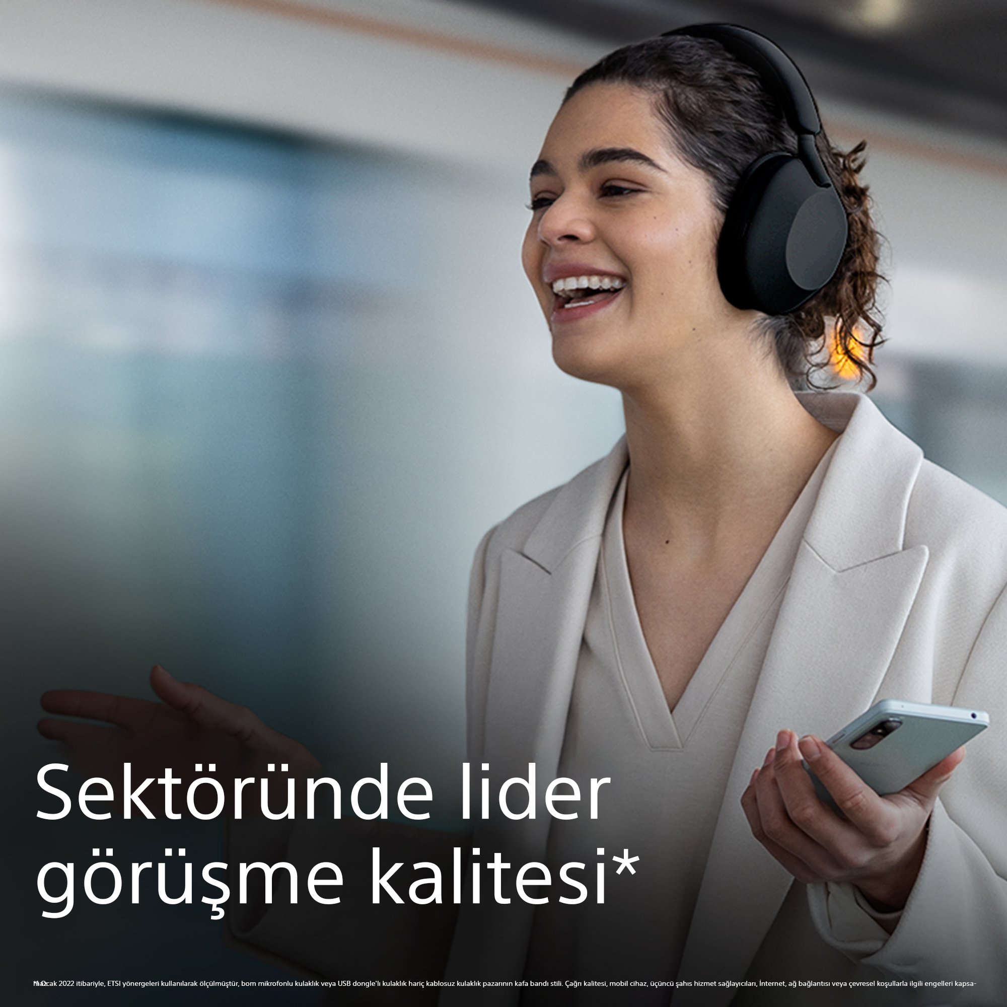 Siyah kulaklık takan ve telefon tutan gülen kadın. Metin: Sektör lideri arama kalitesi.