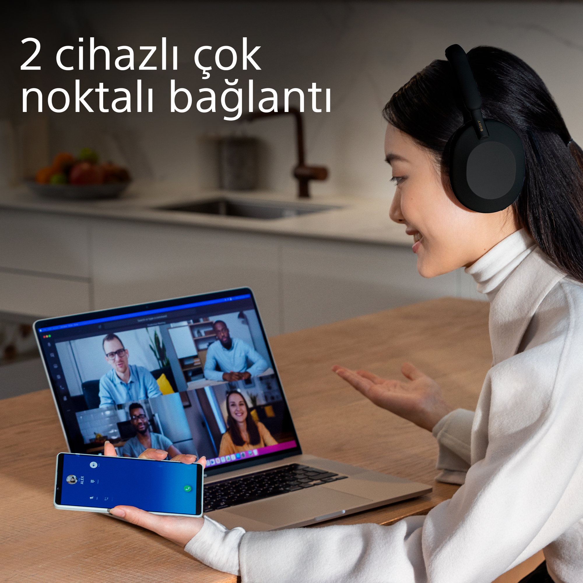 Kulaklık takan, dizüstü ve akıllı telefon kullanan kadın. Ekran, üç kişiyle bir video görüşmesi gösteriyor.