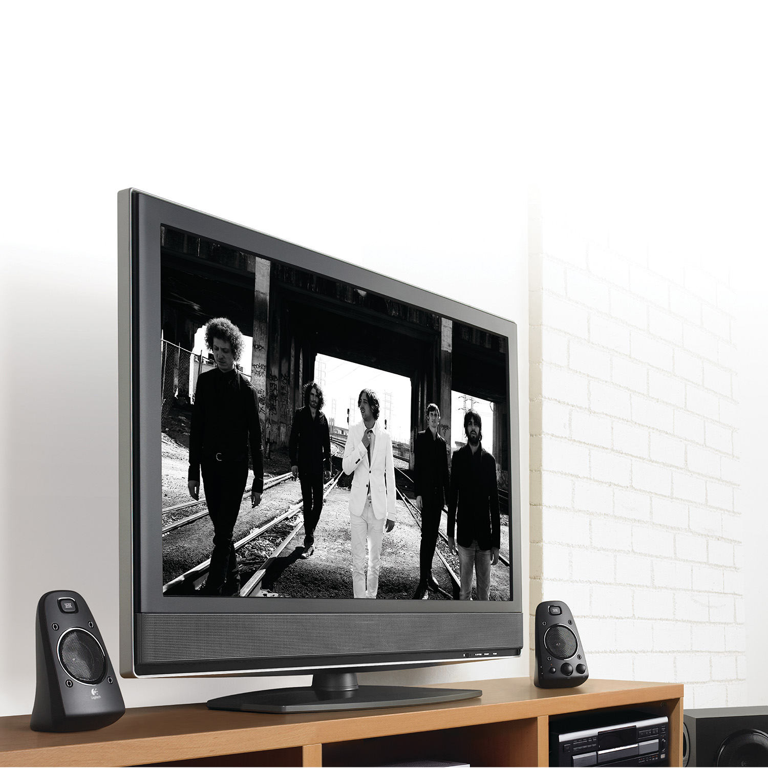 Un grupo de personas caminando por una calle, en una pantalla de TV, con altavoces.