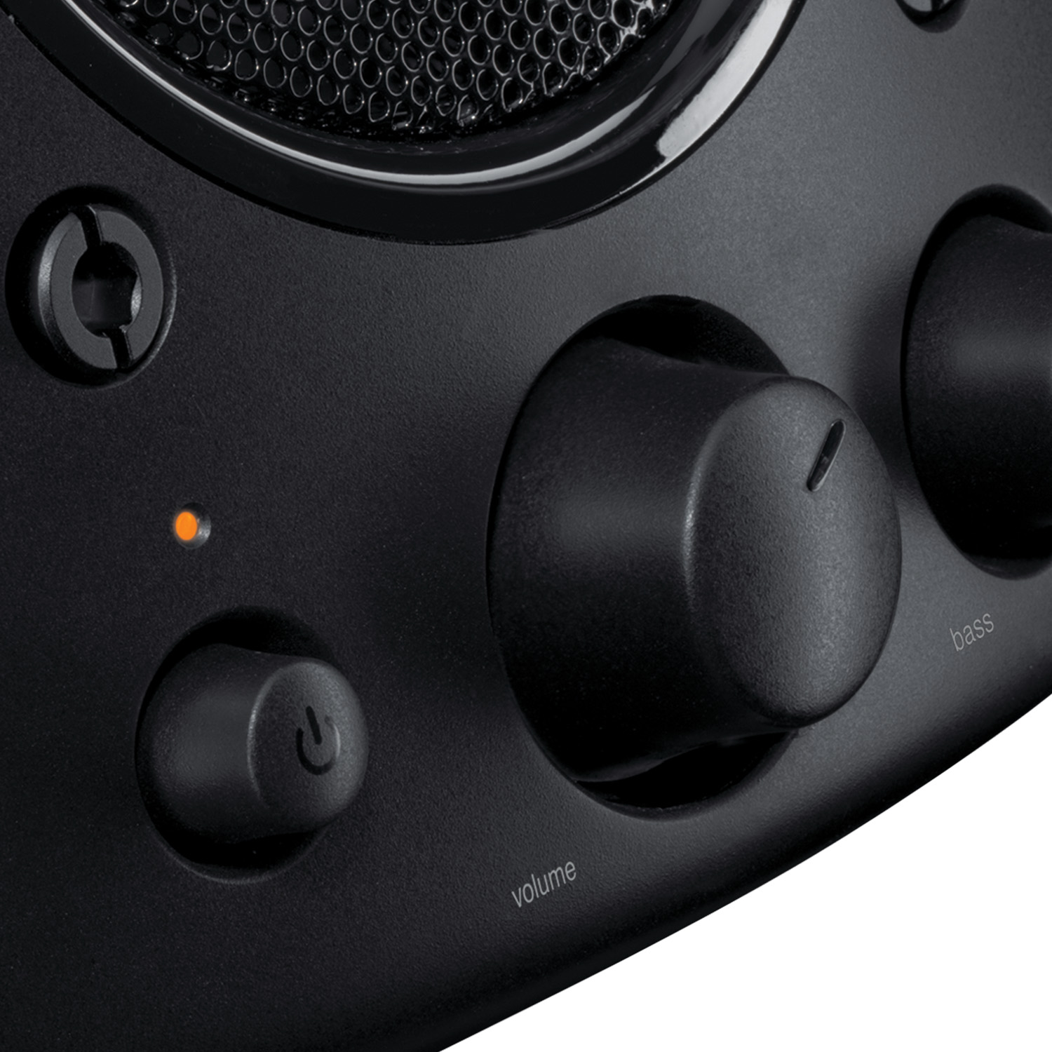 Altavoz negro con perillas de volumen y bajos, un botón de encendido y una luz indicadora naranja.