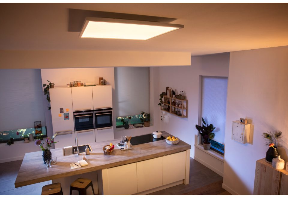 Ooghoogte van een moderne keuken met verlichting, witte kasten en een eiland.