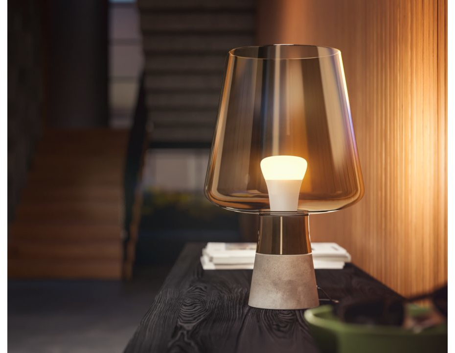 A table lamp with a glass shade, a light bulb, and a wooden table.