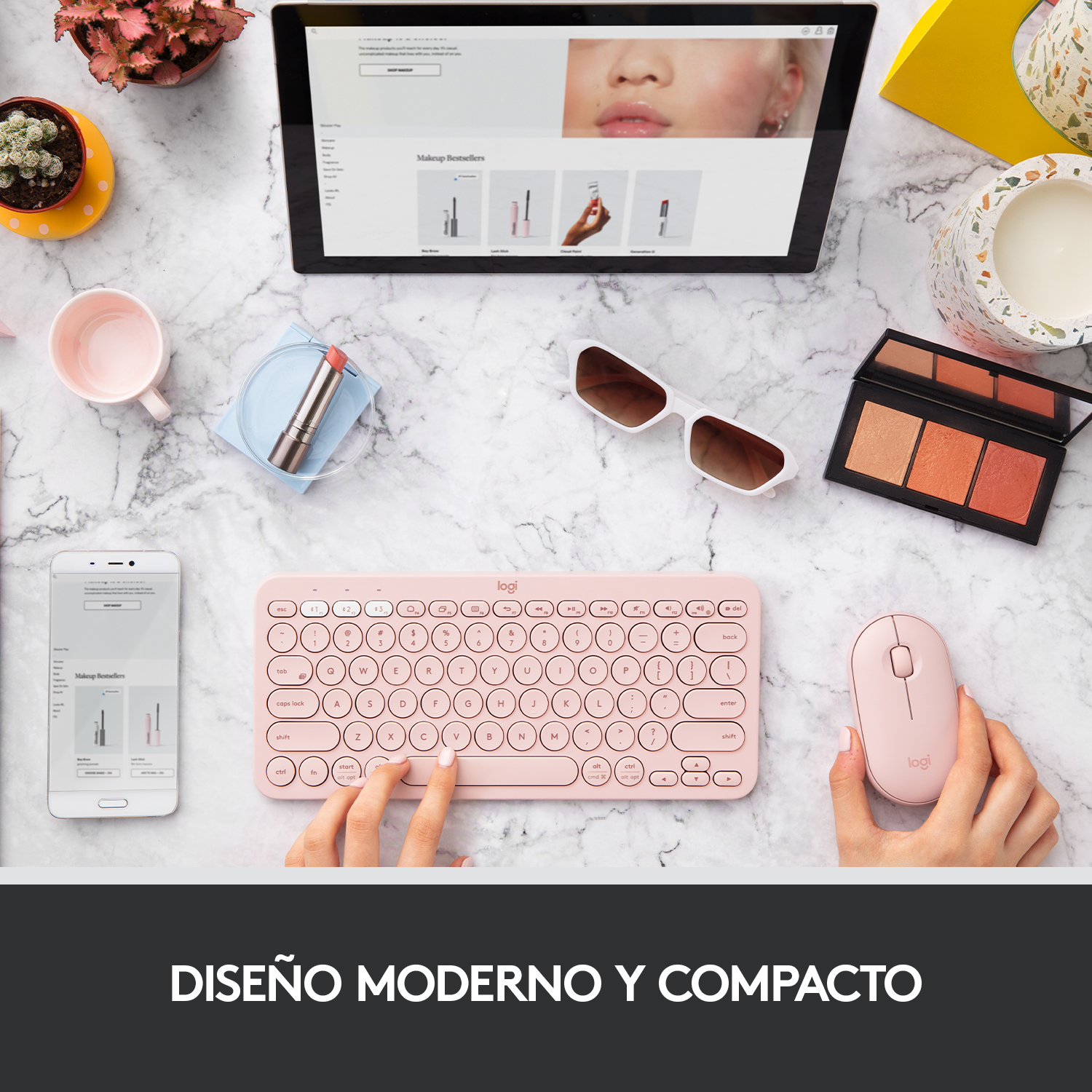Un teclado, ratón y tableta rosas están sobre una superficie de mármol. También hay gafas de sol y maquillaje.