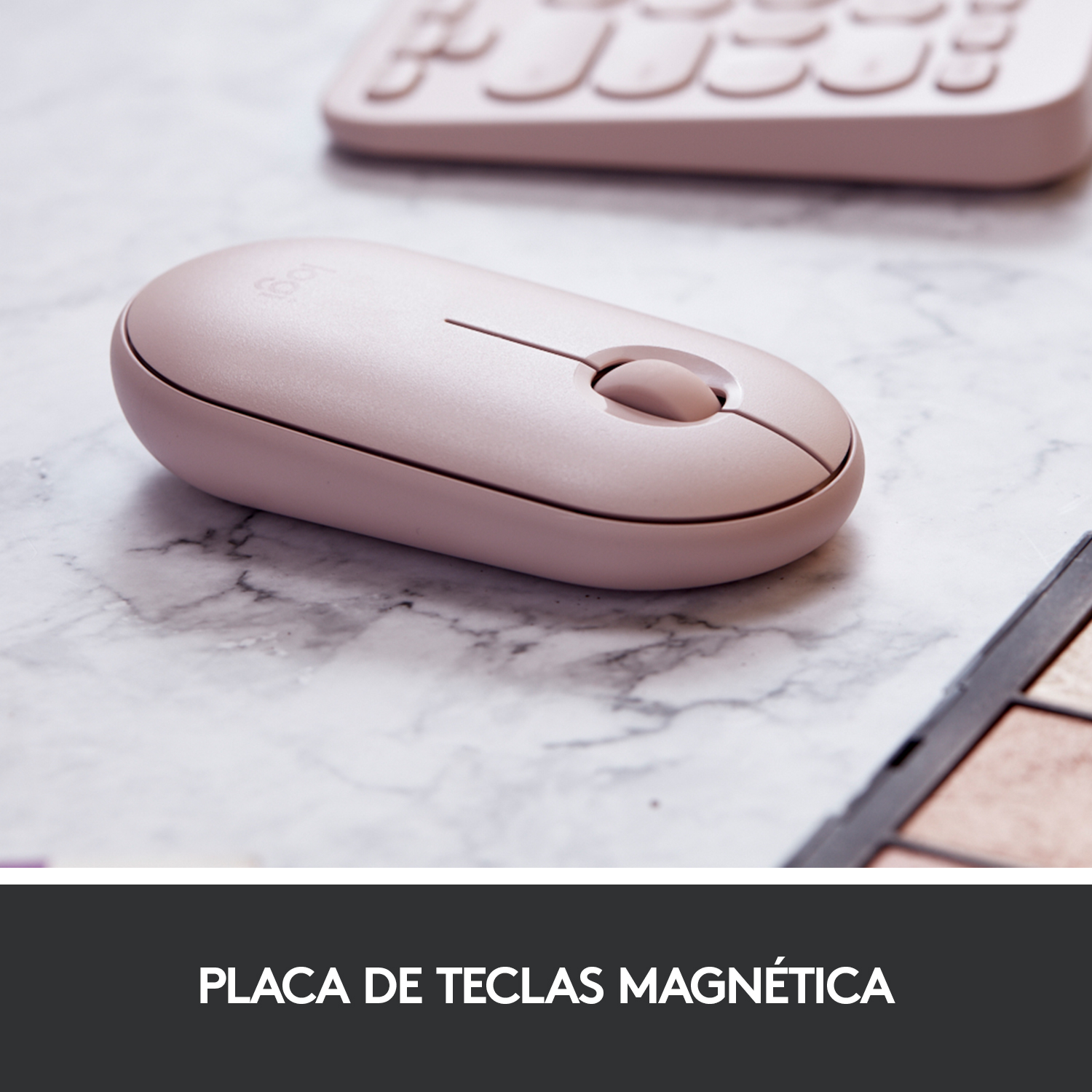 Ratón rosa sobre una superficie de mármol con teclado y paleta de maquillaje.
