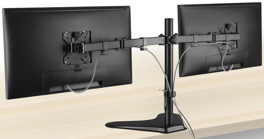 A dual monitor stand with two black monitors on a light wood table.