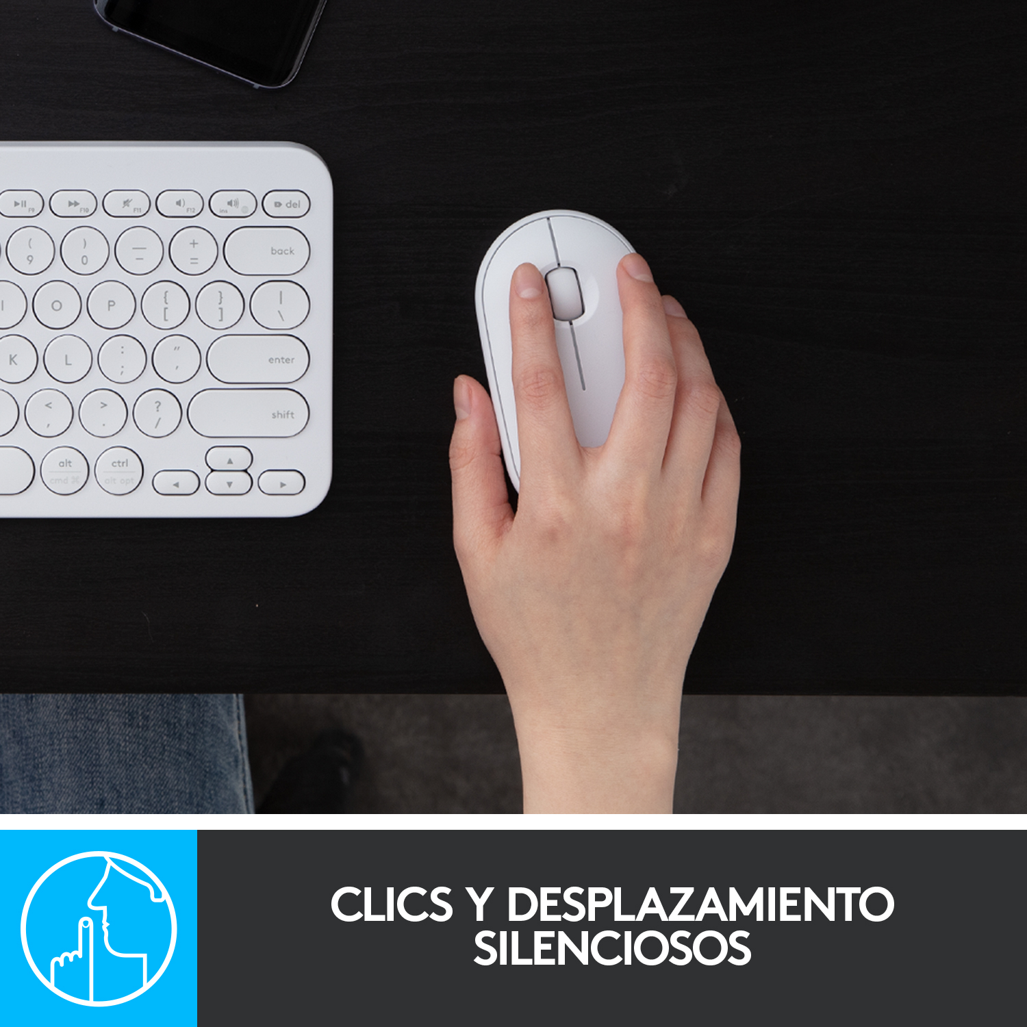 Una persona usando un ratón y teclado blancos en un escritorio negro, primer plano.