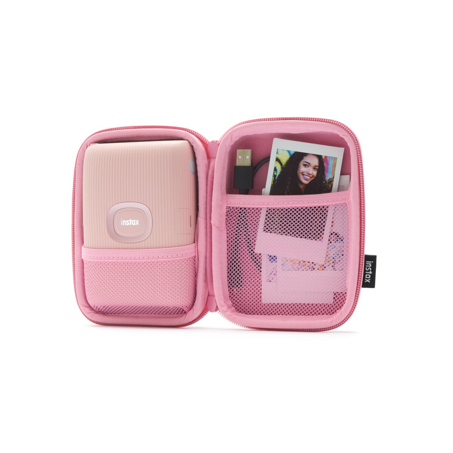 Roze open Instax-etui met printer, foto en accessoires. Witte achtergrond.