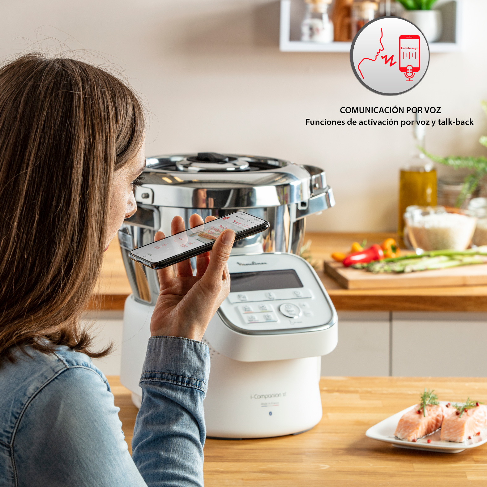Mujer con teléfono cerca de un electrodoméstico de cocina blanco.