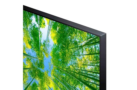Toma de ángulo bajo de una pantalla de TV con árboles verdes y cielo azul.