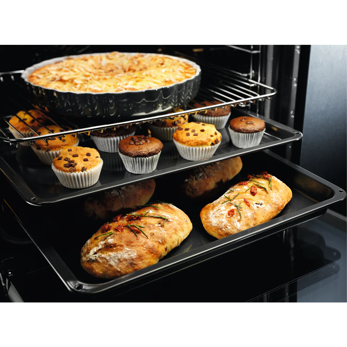 Un horno con productos horneados dentro. Incluye magdalenas, pan y un plato de comida.