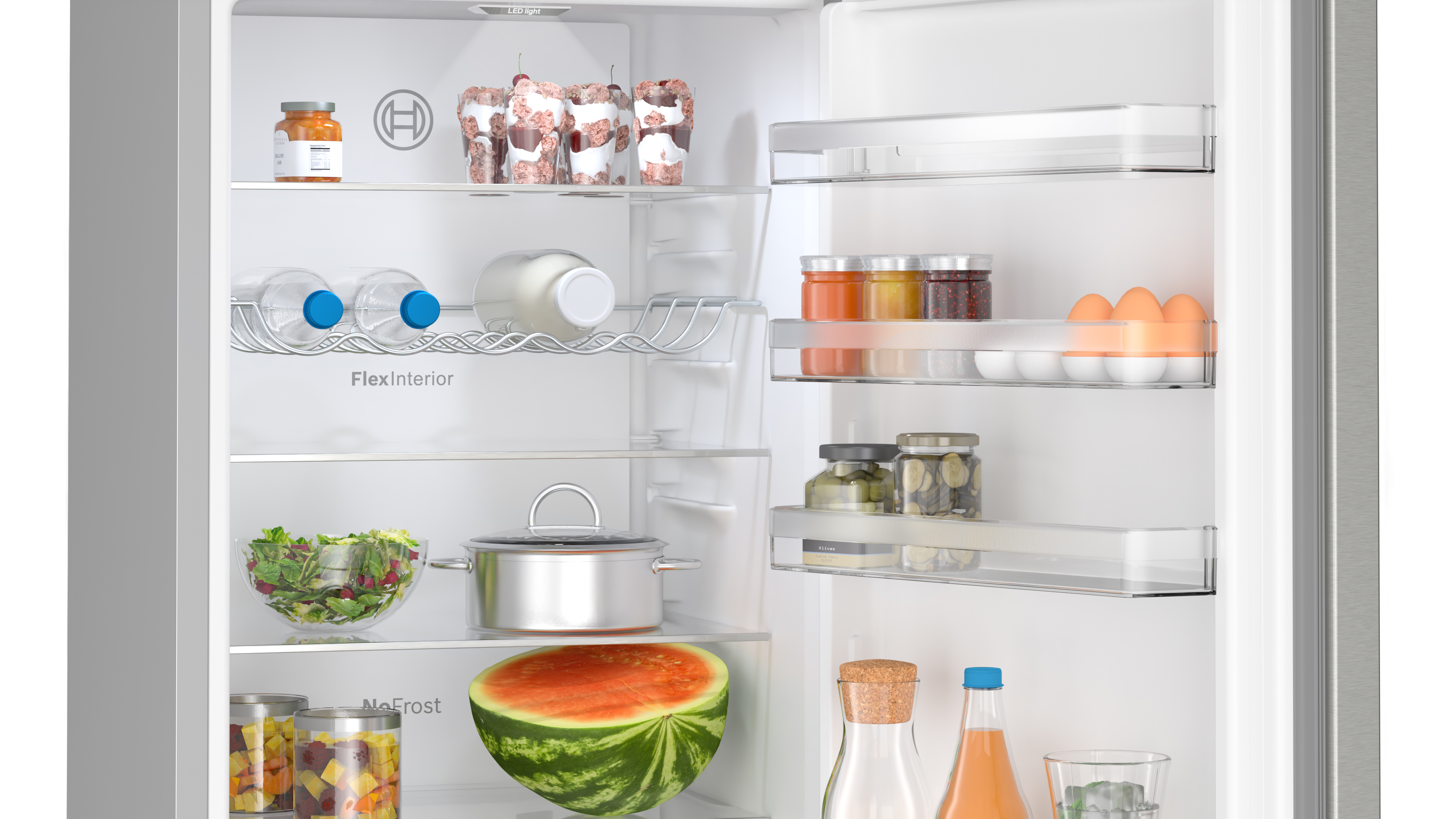 Interior de un refrigerador con estantes que contienen alimentos: frascos, verduras, huevos y bebidas.