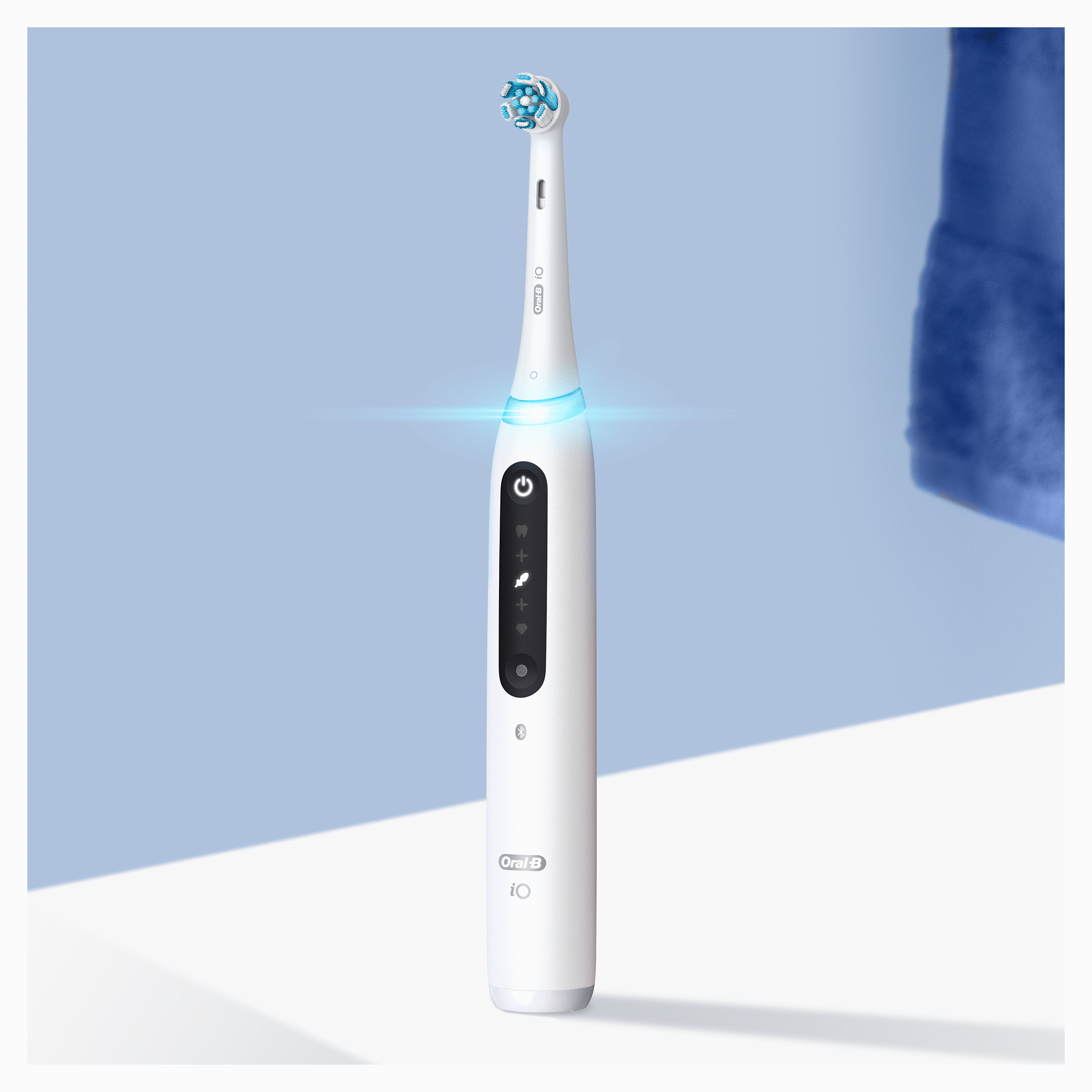 Witte elektrische tandenborstel met blauw licht, blauwe achtergrond.