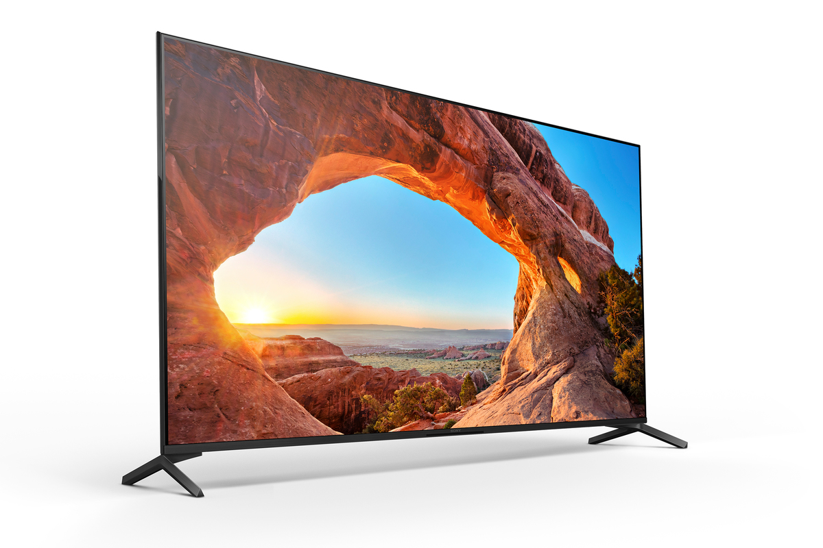 Taş bir kemer ve dağlarla bir manzara sahnesi içeren büyük bir TV ekranı.