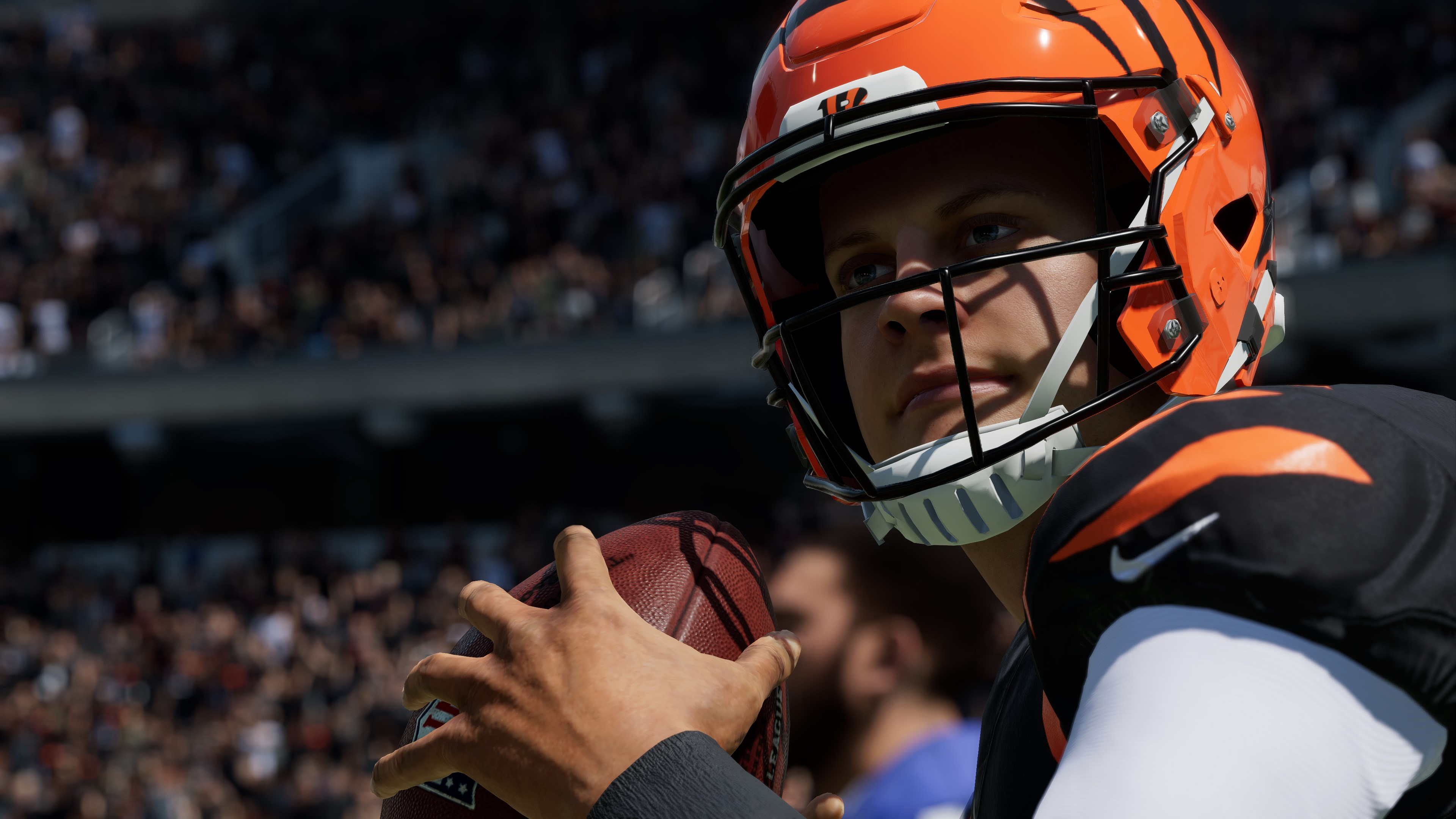 Footballspieler mit orangefarbenem Helm, der einen Ball hält.