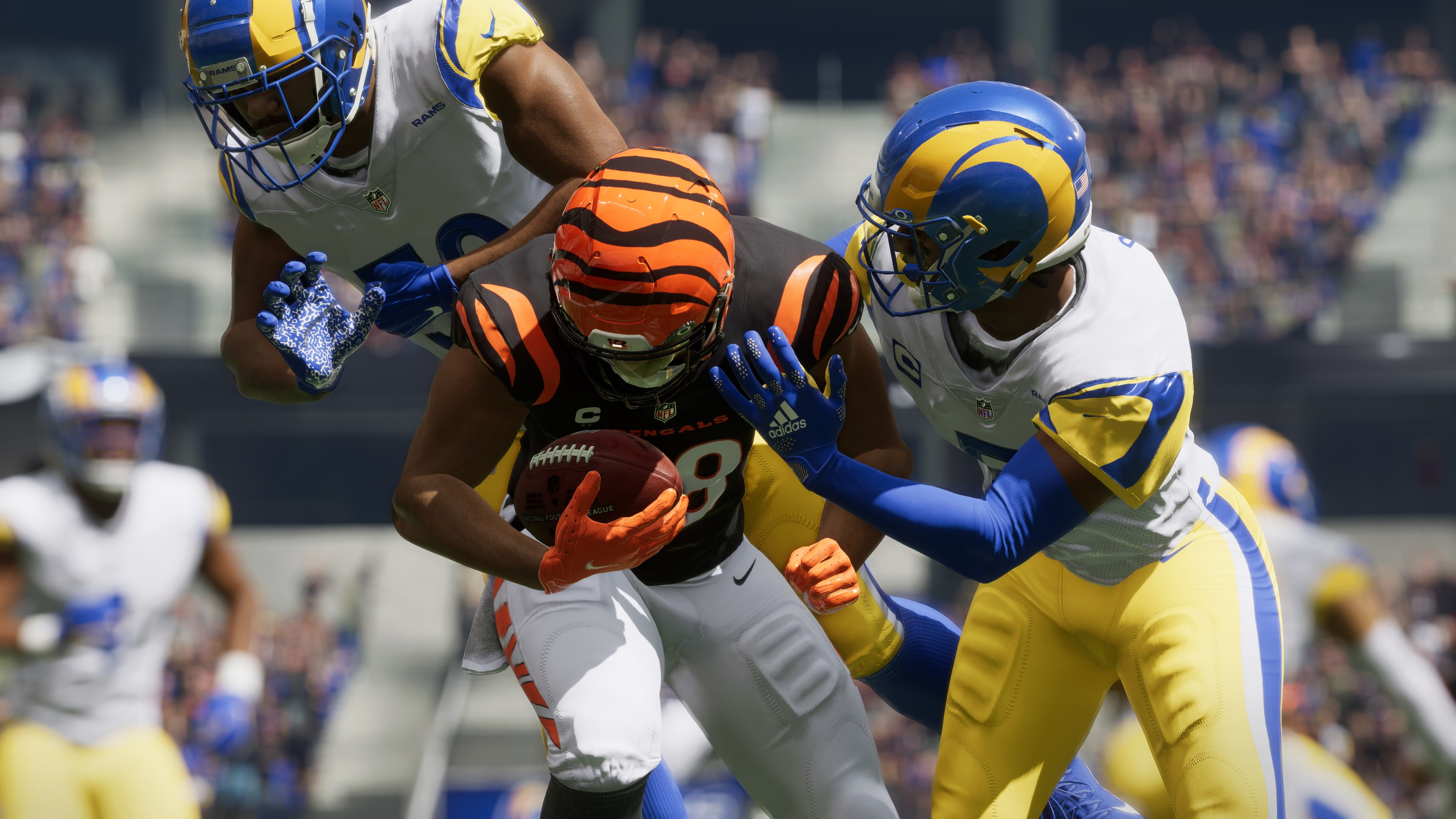 Ein Footballspiel im Gange. Spieler in Bengals- und Rams-Trikots kämpfen um den Ball.