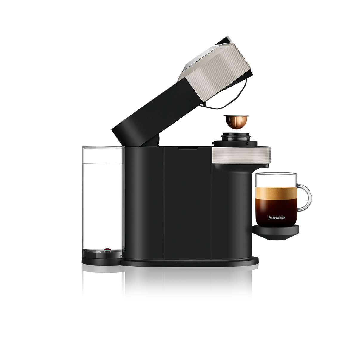 Una cafetera Nespresso con una taza de café. Es negra con un acento plateado.