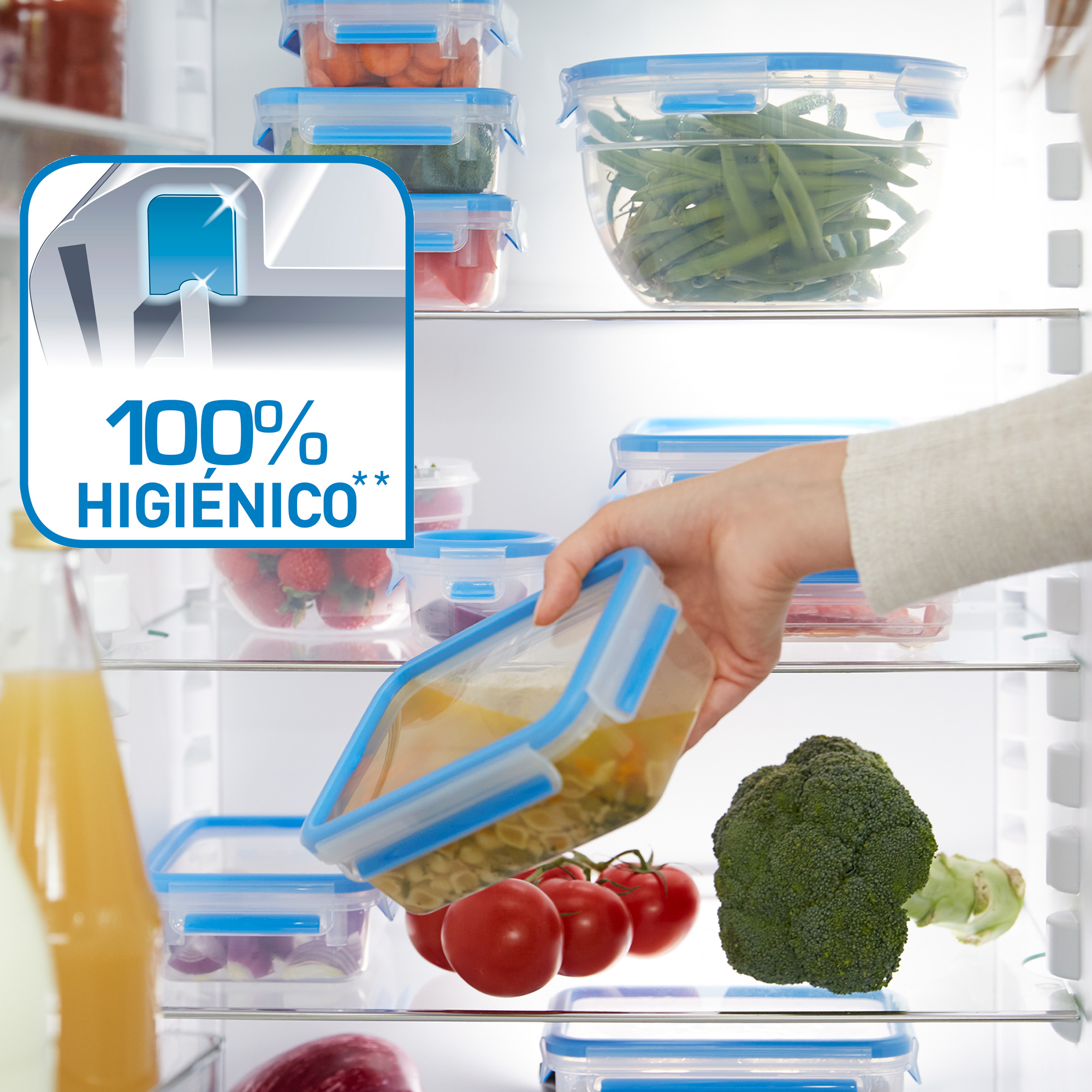 Una mano sacando un recipiente de comida de un refrigerador. Tomates, brócoli y comida.