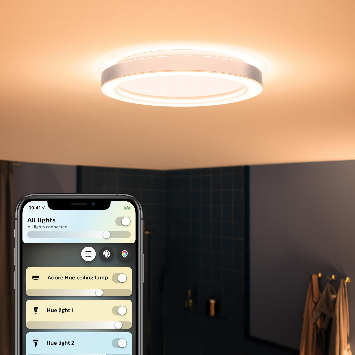 Ronde, witte plafondlamp. Smart home app op de telefoon.