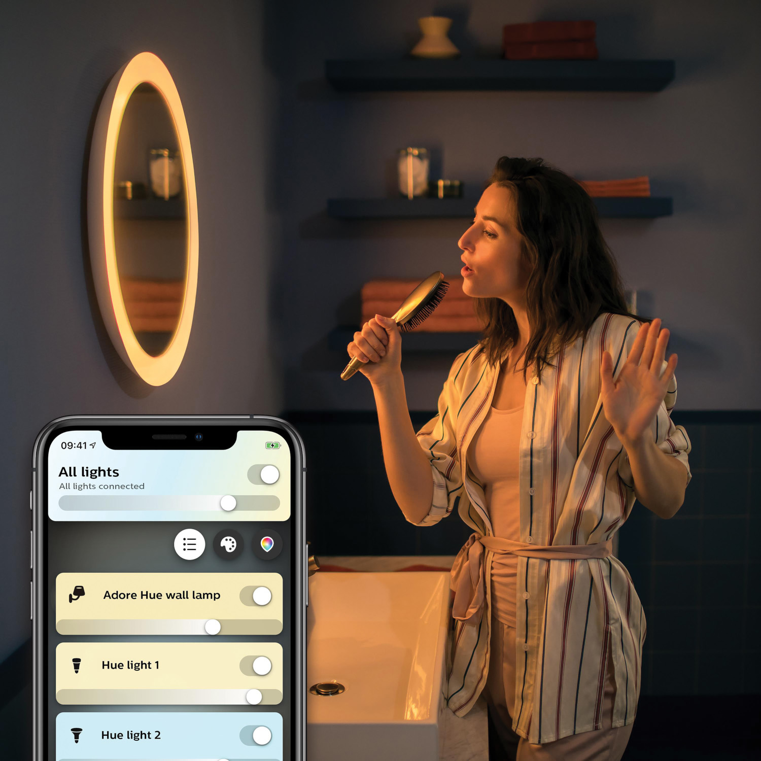 Femme dans salle de bain chante avec brosse. Téléphone affiche application domotique.