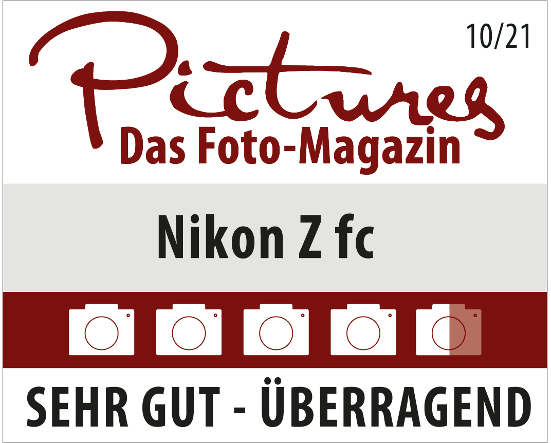 Appareil photo Nikon Z fc avec un badge de récompense, fond blanc.