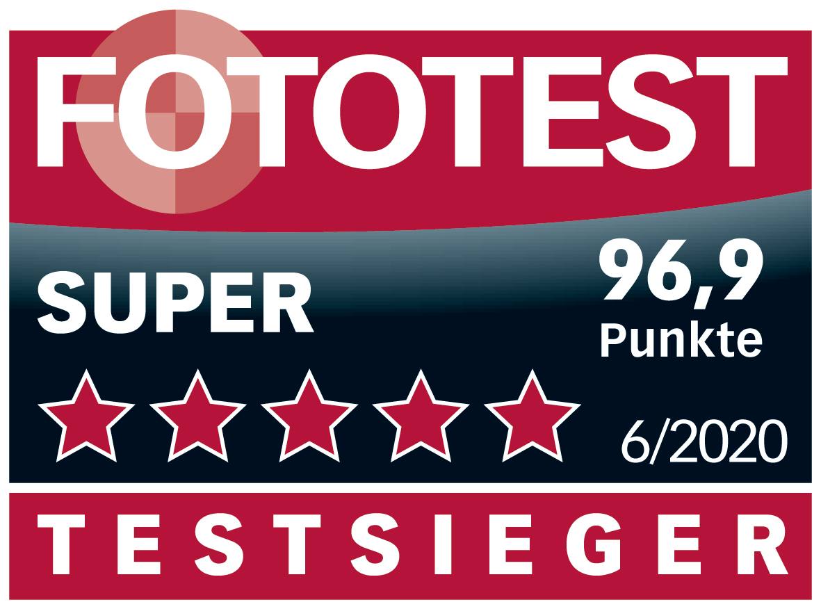 Une bannière rouge et blanche qui dit 'FOTOTEST' avec 'SUPER' et 'TESTSIEGER' affichés.