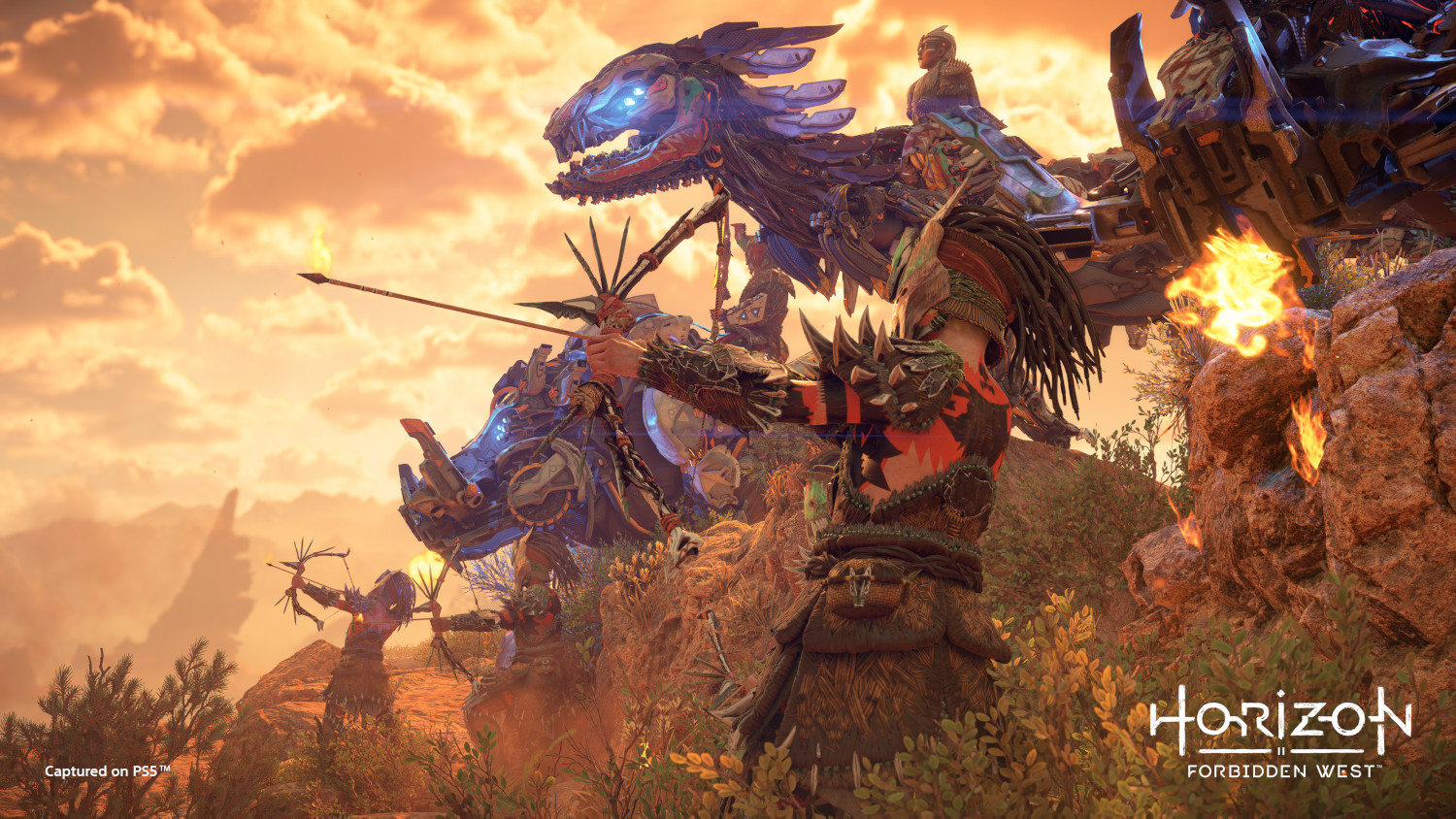 A warrior with a bow and arrow aims at a mechanical beast during sunset.