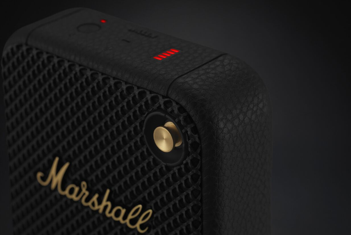 Close-up van een zwarte Marshall speaker, met details. Gouden Marshall tekst en rode lampjes.