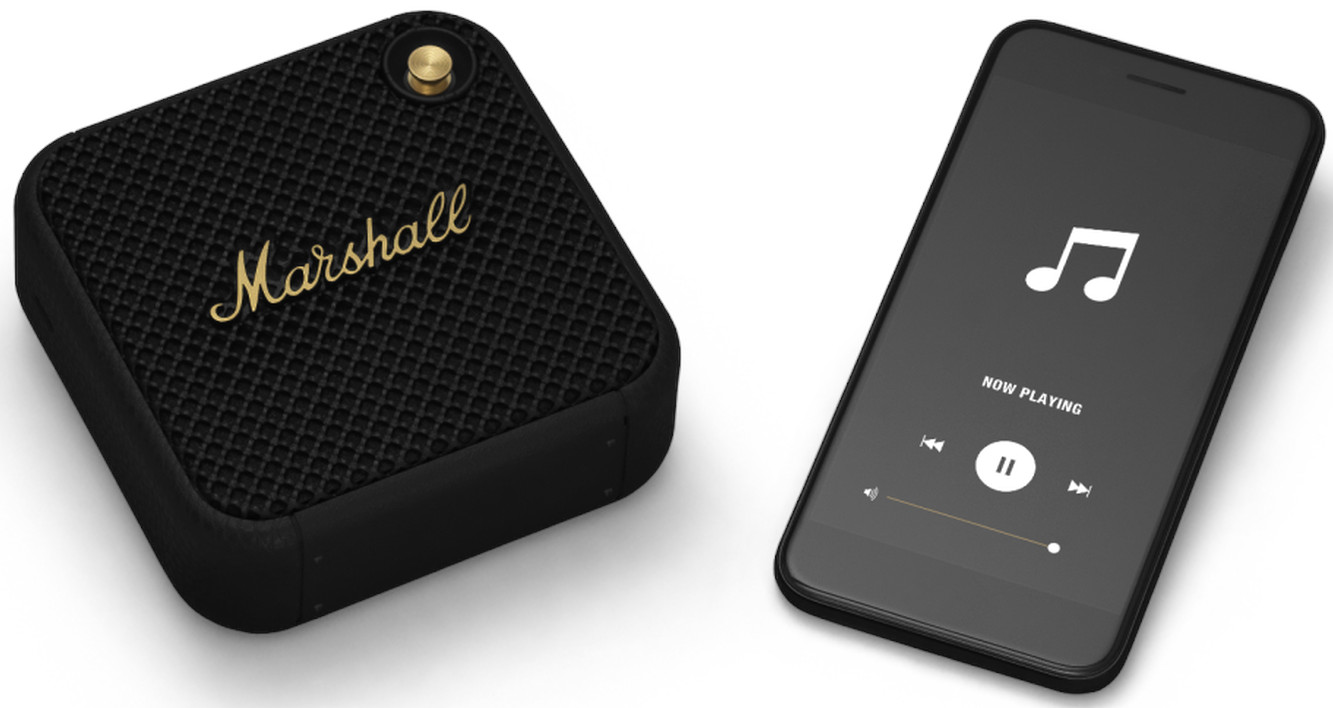 Een zwarte Marshall-luidspreker met een smartphone die muziek afspeelt. Beide staan op een wit oppervlak.