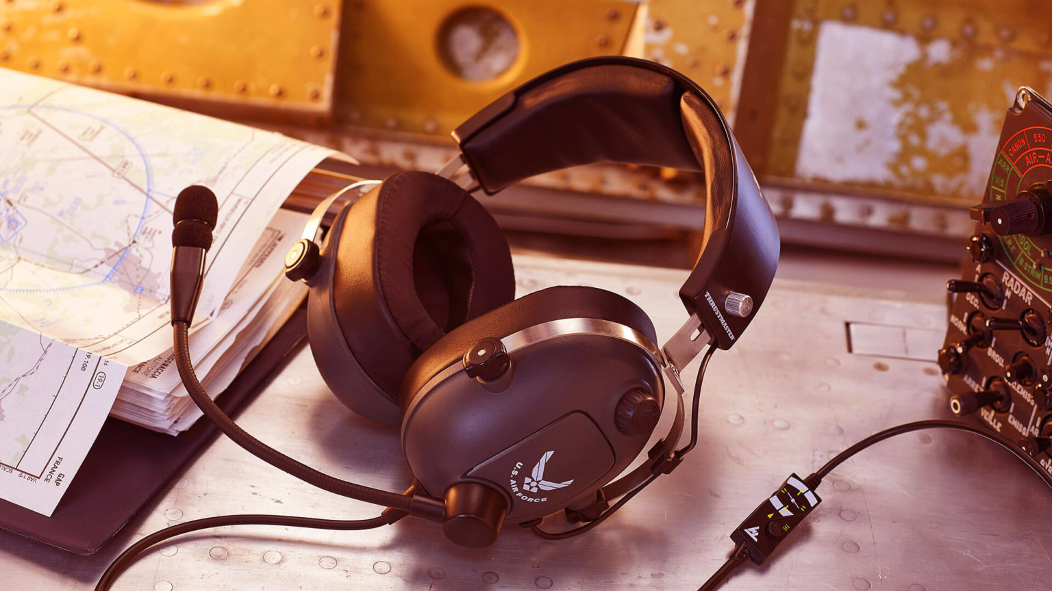 Schwarzes Luftfahrt-Headset mit Mikrofon auf Metalltisch neben Karte und Funkgerät.