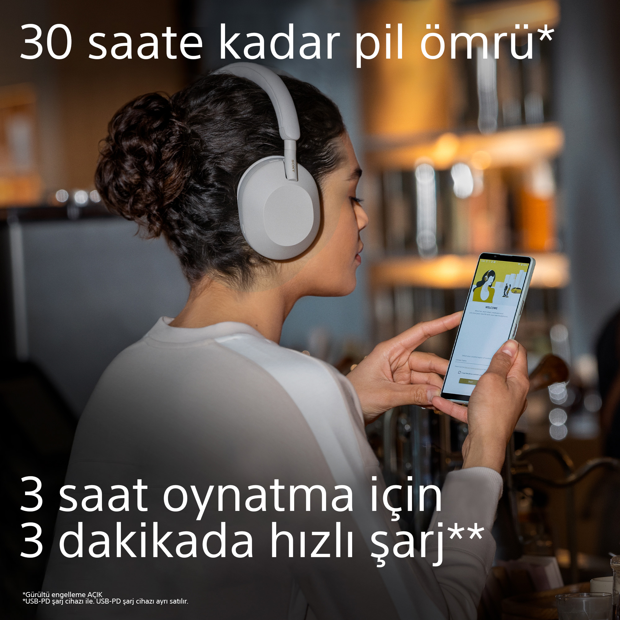 Kulaklık takan, telefon tutan bir kadın, pil ömrü ve şarj hakkında Türkçe metin.