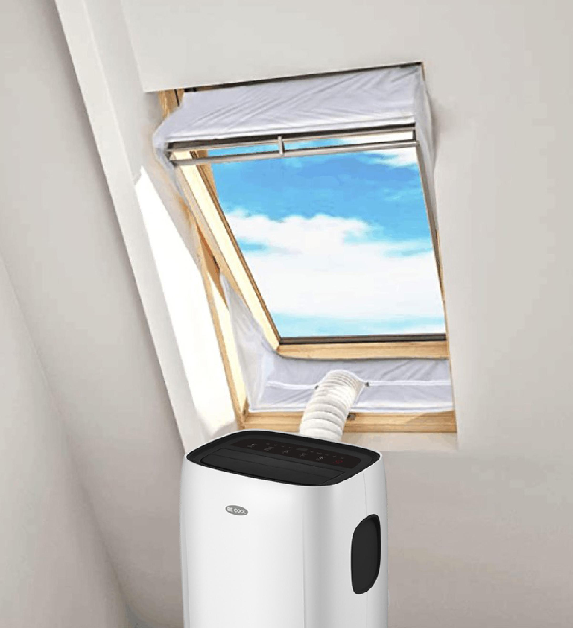Ein weißer, tragbarer Klimaanlage steht vor einem Dachfenster.