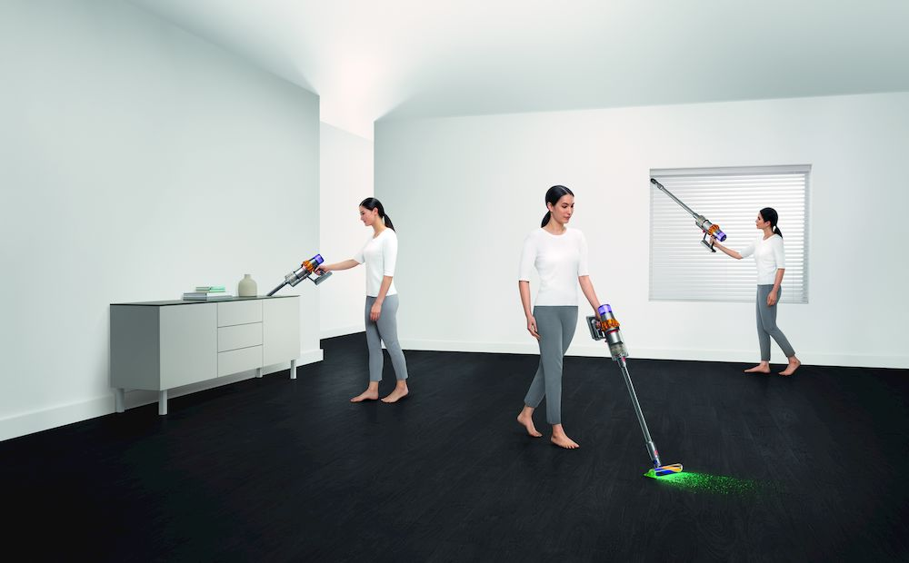 Vrouw die een stofzuiger gebruikt in een kamer. Drie weergaven: tafel schoonmaken, lopen en vloer schoonmaken.