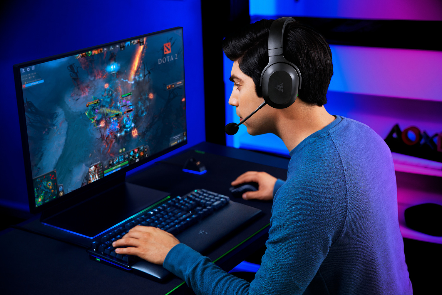 Un giocatore con le cuffie gioca a un gioco su un monitor grande.