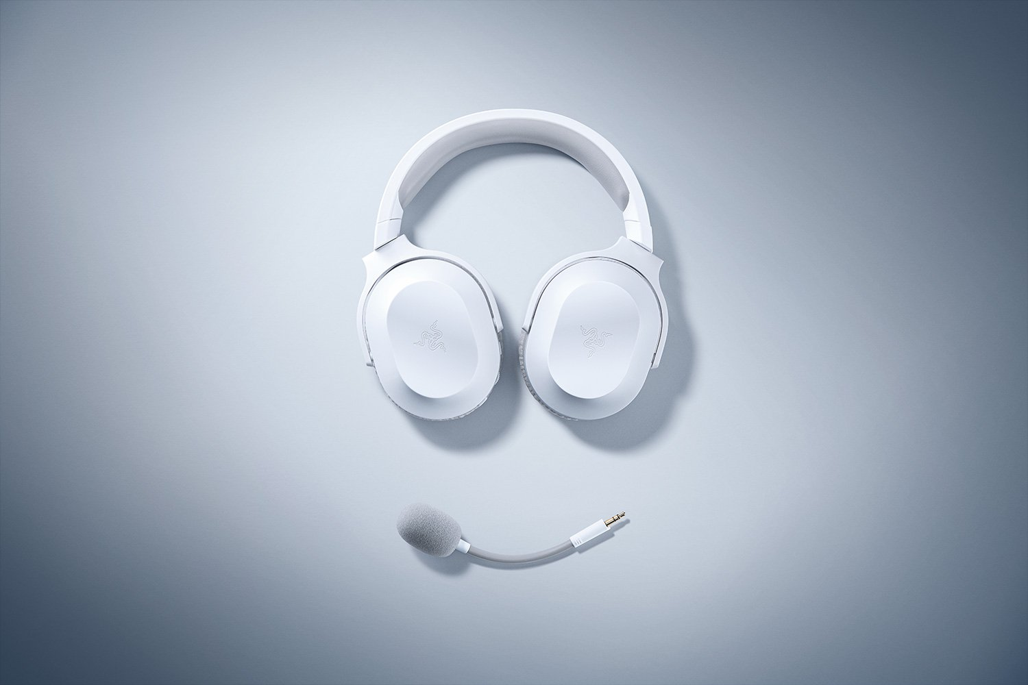 Weißes Headset mit Mikrofon auf hellgrauer Oberfläche. Klares, minimalistisches Design.