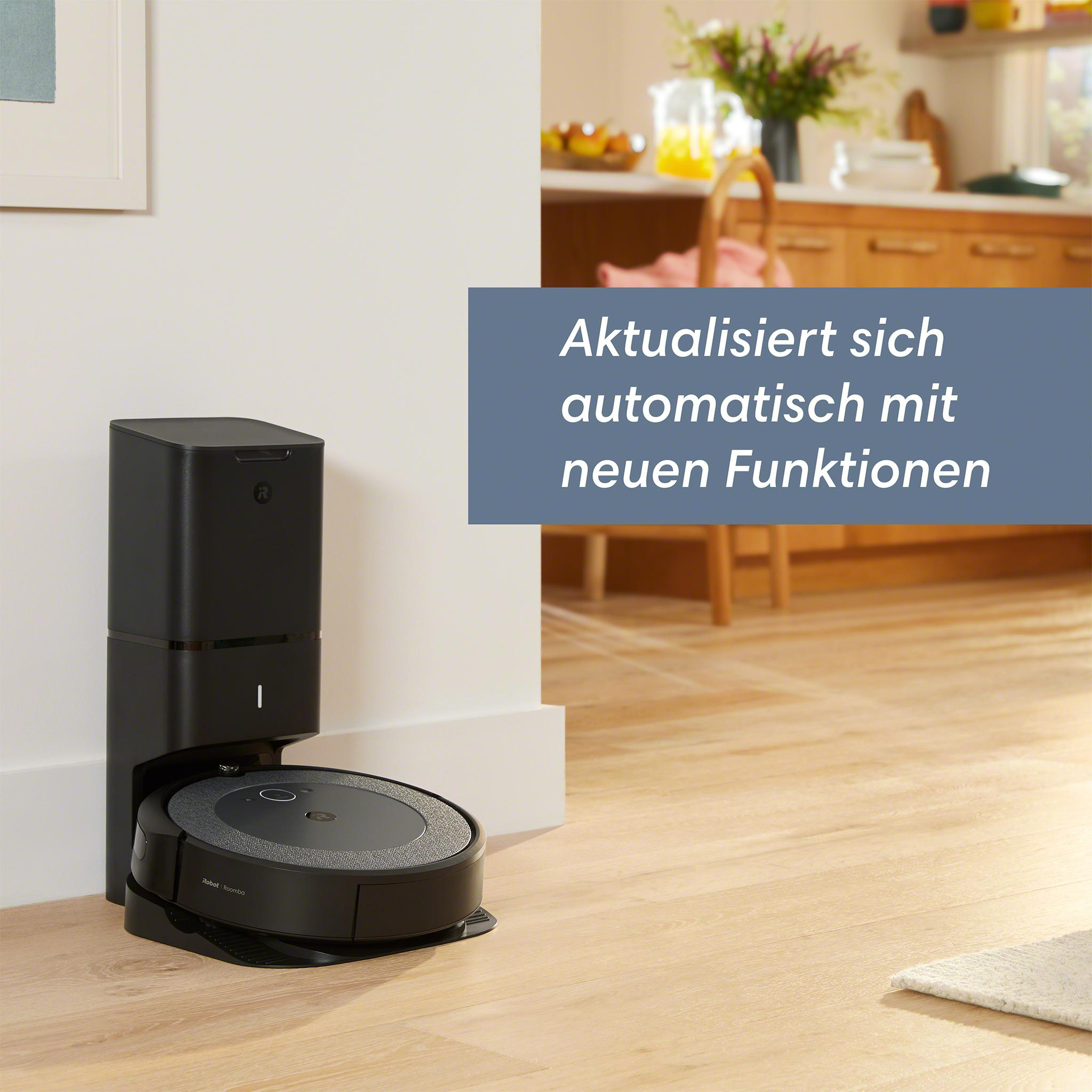 Schwarzer Roboter-Staubsauger auf Ladegerät. Holzboden, weiße Wand, Text in blauer Box.