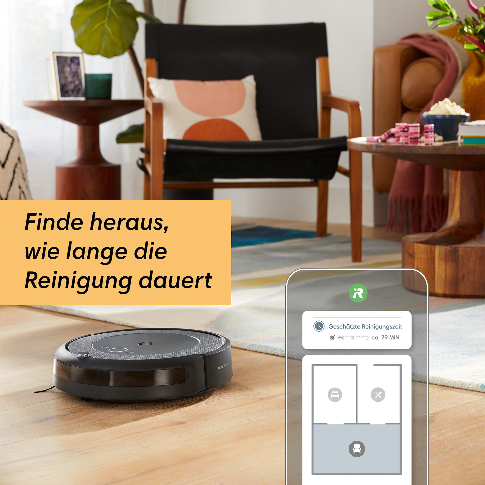 Ein Roboter-Staubsauger auf Holzboden, mit einem Telefon, das die Reinigungszeit anzeigt.