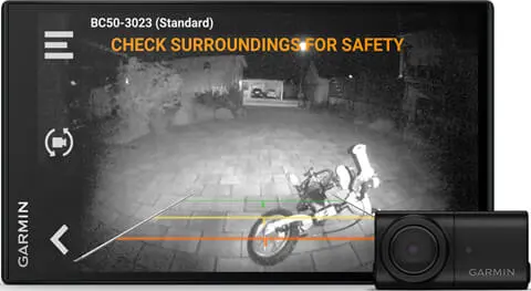 Schwarzer Bildschirm mit Nachtsicht, zeigt ein Motorrad, Text: ÜBERPRÜFEN SIE DIE UMGEBUNG FÜR SICHERHEIT.