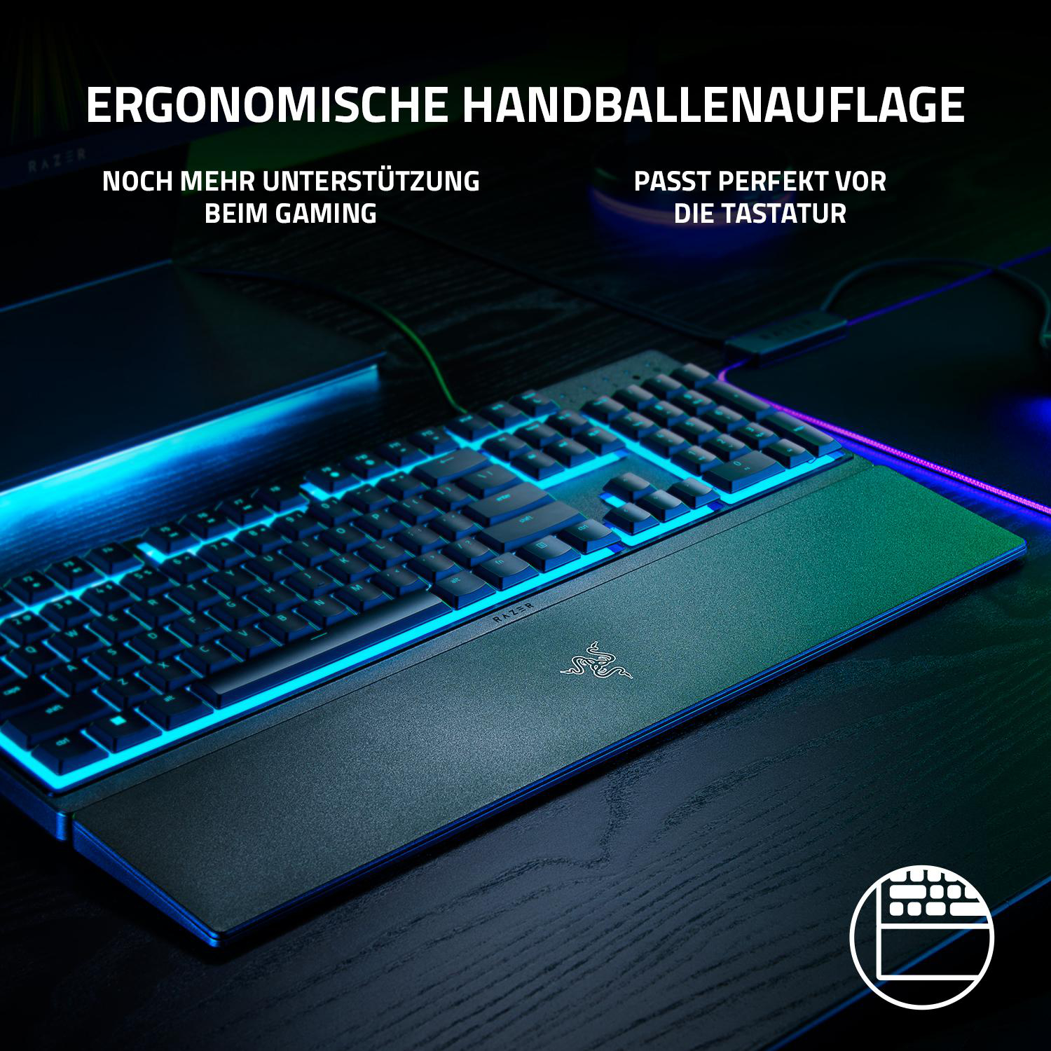Eine schwarze Tastatur mit blauen und grünen Lichtern und einer Handballenauflage.