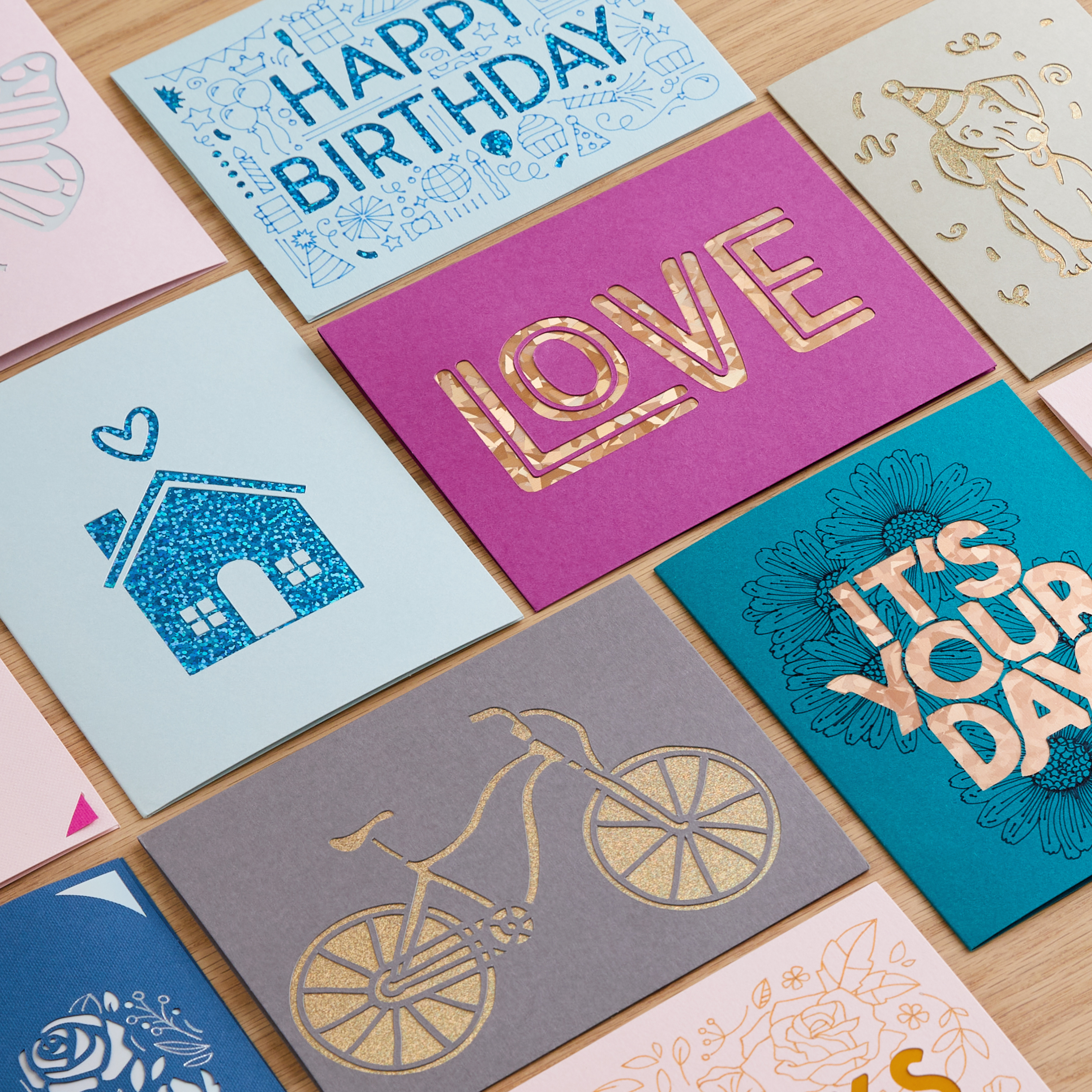 Karten mit Ausschnittdesigns auf Holz. Themen sind Geburtstag, Liebe und andere festliche Anlässe mit verschiedenen Farben.
