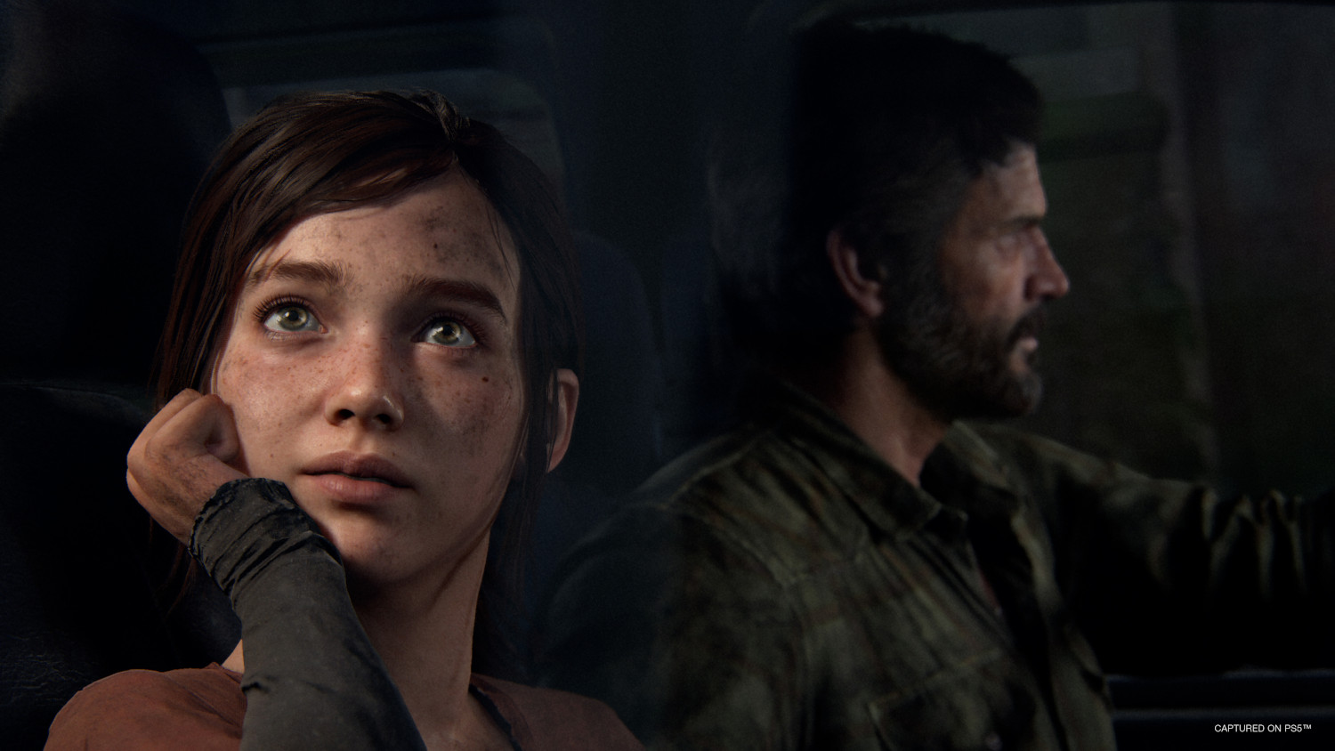 Deux personnes dans une voiture regardant par la fenêtre, avec une expression triste sur le visage de la fille.