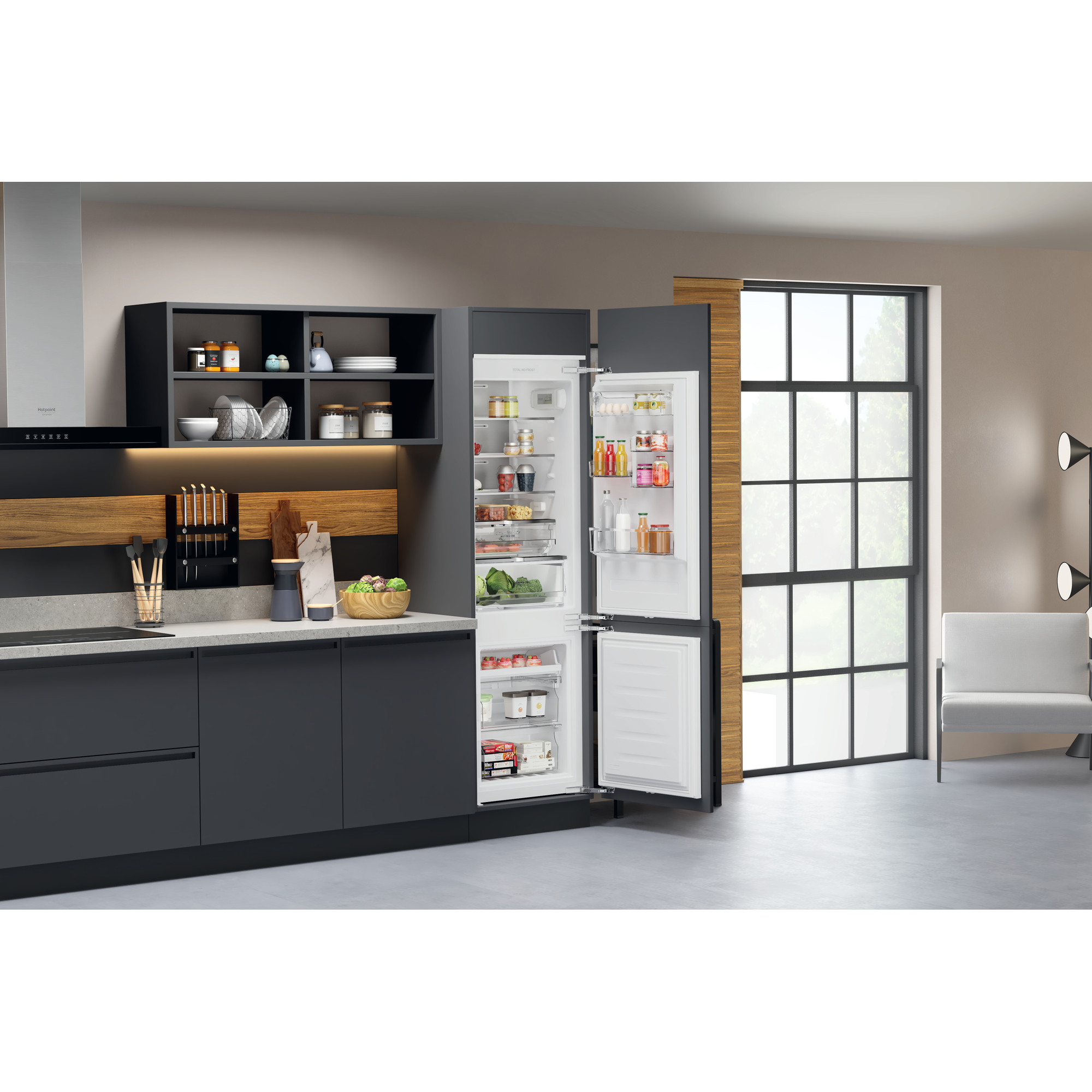 Eine moderne Küche mit Kühlschrank, Schränken und einem Fenster.